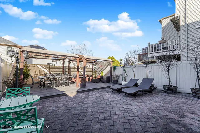 a view of a patio with table and chairs potted plants with wooden fence