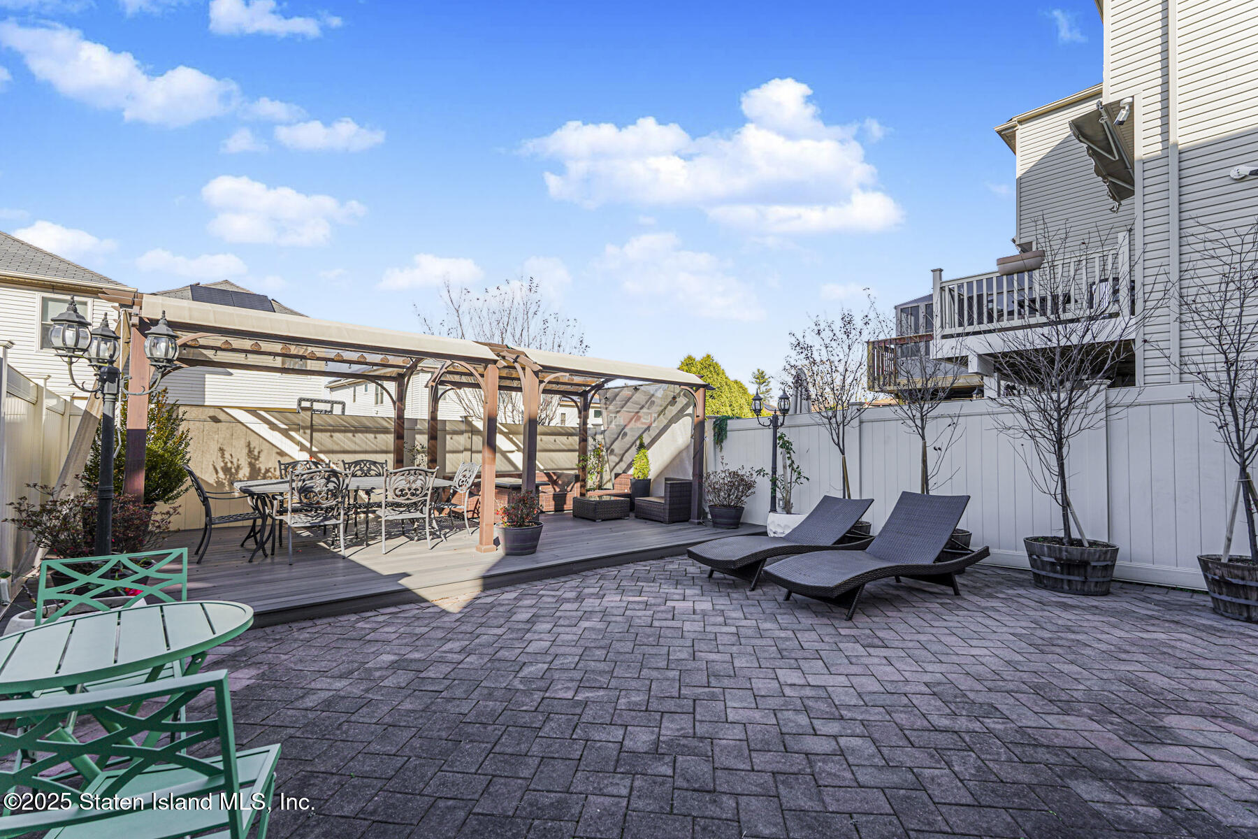 1352 Forest Hill Road Staten Island, NY 10314 - Photo 18 of 19 a view of a patio with table and chairs potted plants with wooden fence