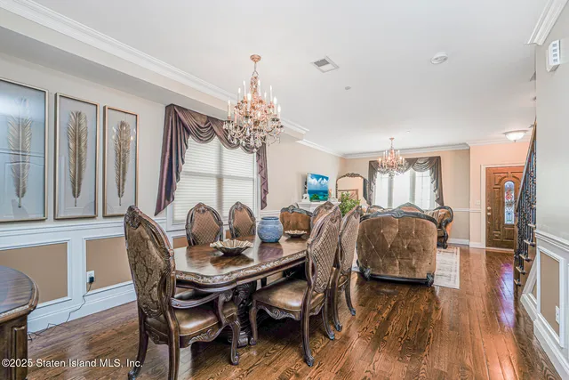 a dining room with furniture a chandelier and wooden floor