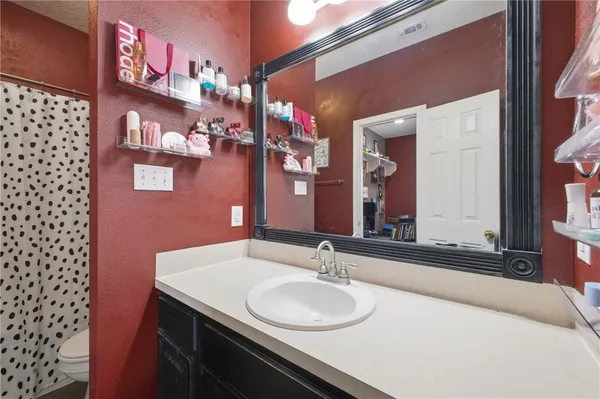 a bathroom with a granite countertop sink a mirror and a shower