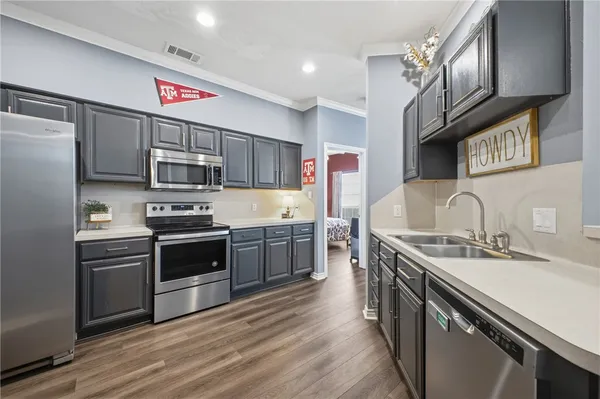 a kitchen with stainless steel appliances granite countertop a sink stove microwave and refrigerator
