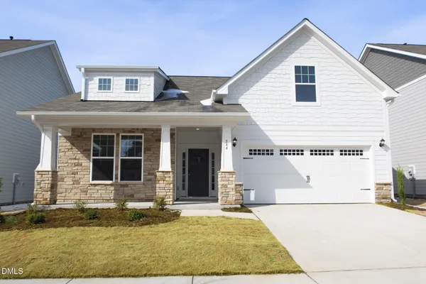 a view of a white house with large windows and plants