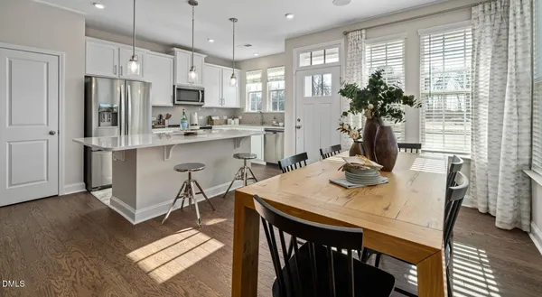 a kitchen with a table chairs refrigerator and microwave