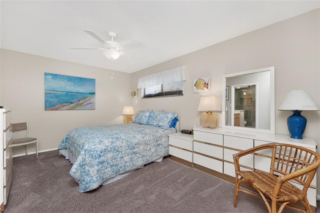 2955 North Beach Road, Unit B614 Englewood, FL 34223 - Photo 23 of 67 a bedroom with a bed and a chandelier