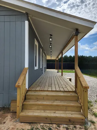 a view of a house with backyard and porch