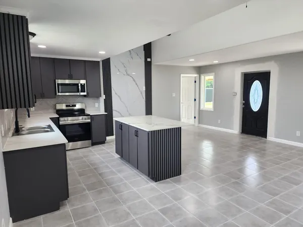 a kitchen with stainless steel appliances granite countertop a stove a sink and a refrigerator