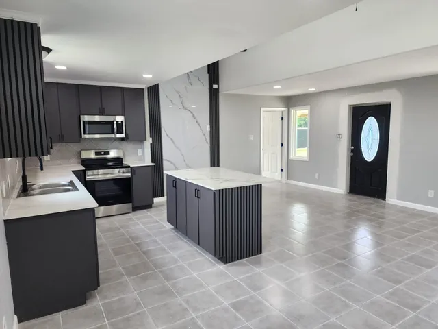 a kitchen with stainless steel appliances granite countertop a stove a sink and a refrigerator