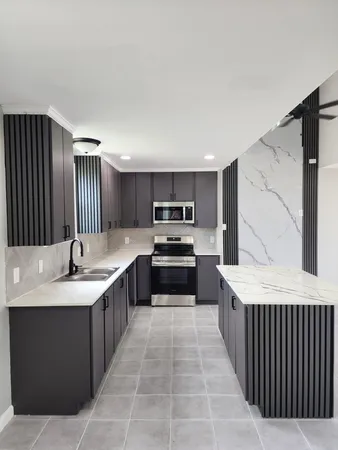 a large kitchen with a stove top oven and cabinets