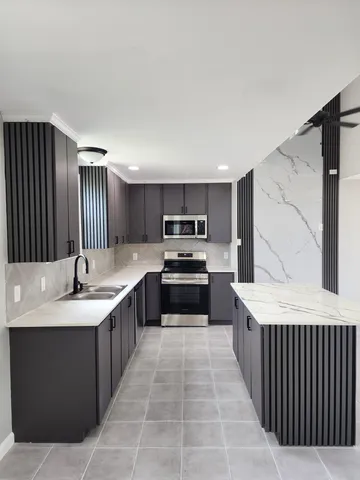 a large kitchen with a stove top oven and cabinets