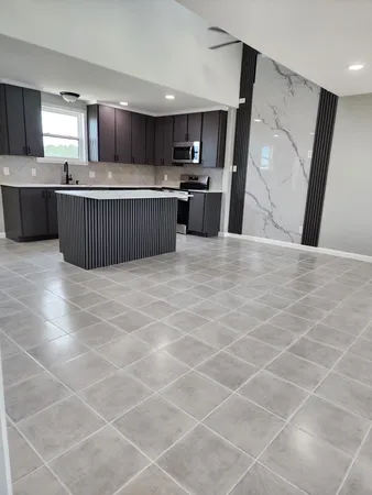 a kitchen with stainless steel appliances a sink a stove a microwave a sink a refrigerator and cabinets