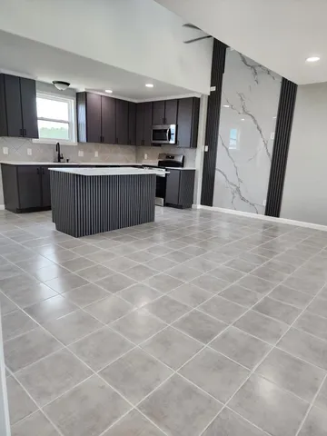 a kitchen with stainless steel appliances a sink a stove a microwave a sink a refrigerator and cabinets