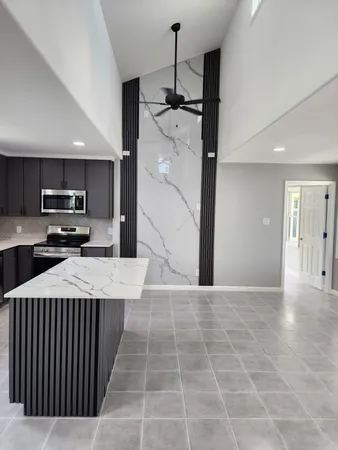 a kitchen with kitchen island granite countertop a refrigerator a sink and a stove