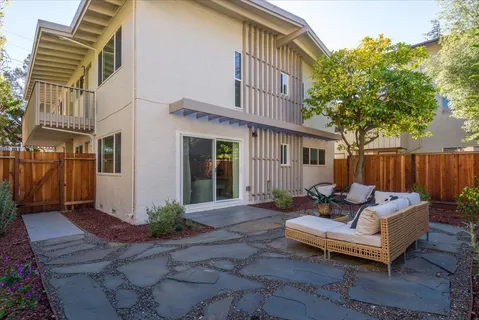 a view of a patio with couches and a table and chairs with wooden fence