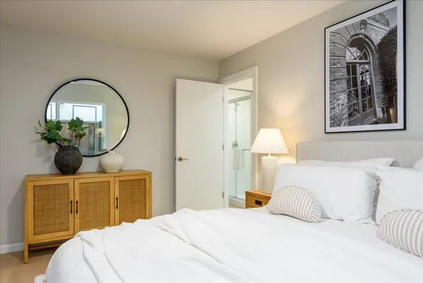 a bedroom with a bed mirror and window
