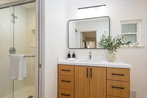 a bathroom with a sink vanity and a mirror