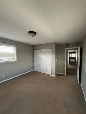 an empty room with windows and closet