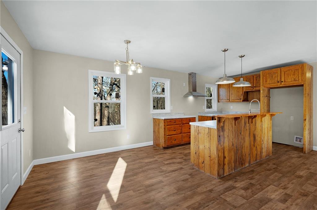 78 Ridgeback Road Talking Rock, GA 30175 - Photo 10 of 35 a kitchen with stainless steel appliances granite countertop a refrigerator a sink dishwasher a stove and a dining table with wooden floor