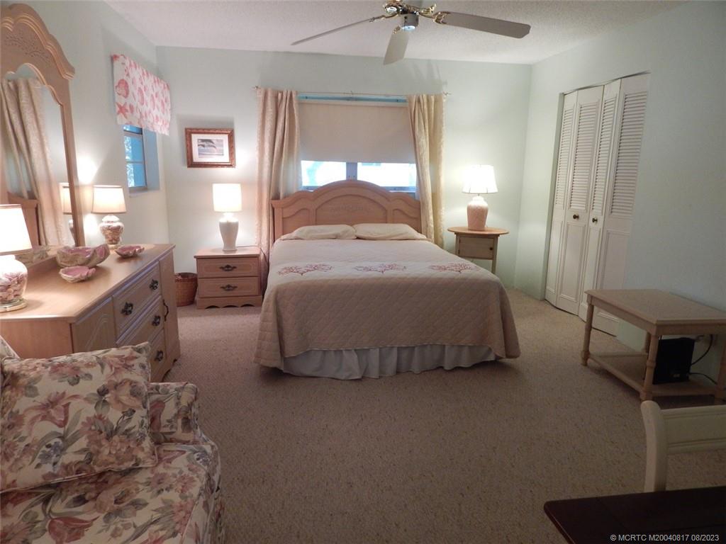 2950 Southeast Ocean Boulevard, Unit 55 Stuart, FL 34996 - Photo 12 of 24 a bedroom with a bed and a table in it