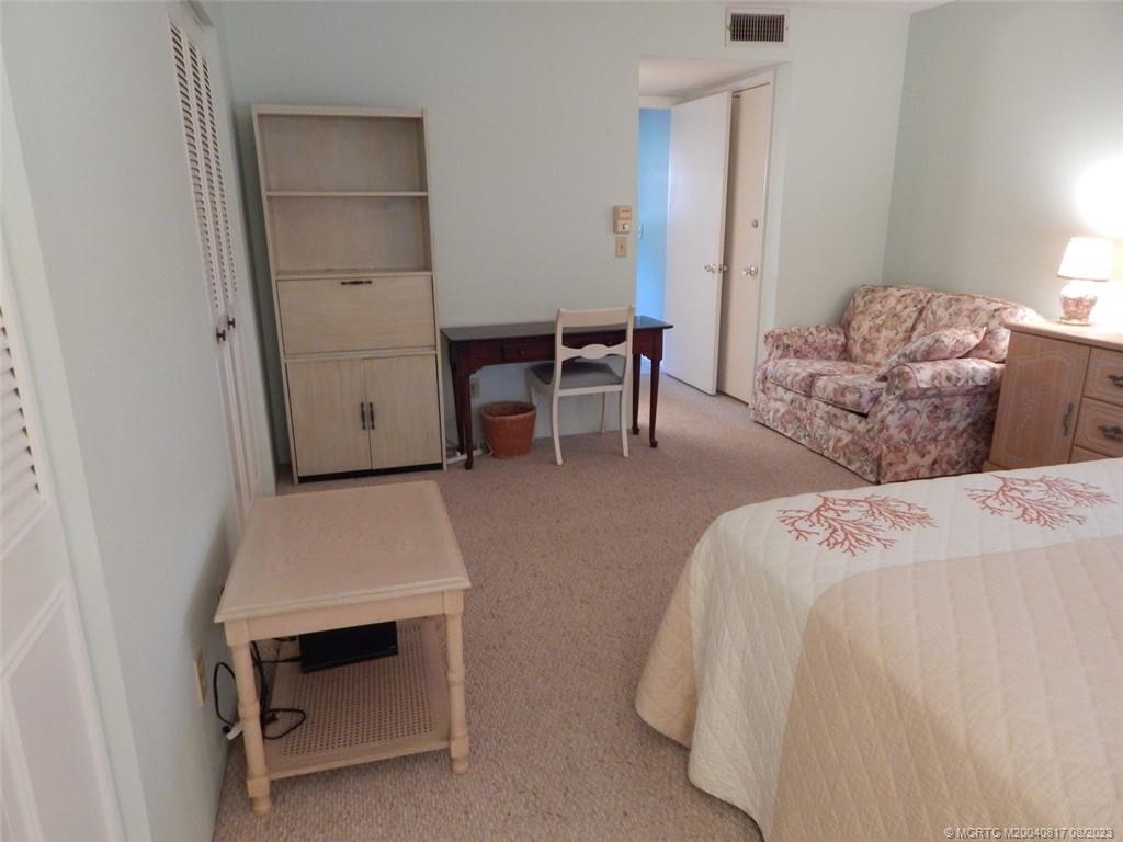 2950 Southeast Ocean Boulevard, Unit 55 Stuart, FL 34996 - Photo 14 of 24 a bedroom with a bed and a cabinets