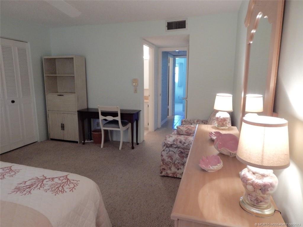 2950 Southeast Ocean Boulevard, Unit 55 Stuart, FL 34996 - Photo 15 of 24 a bedroom with furniture and a wooden floor