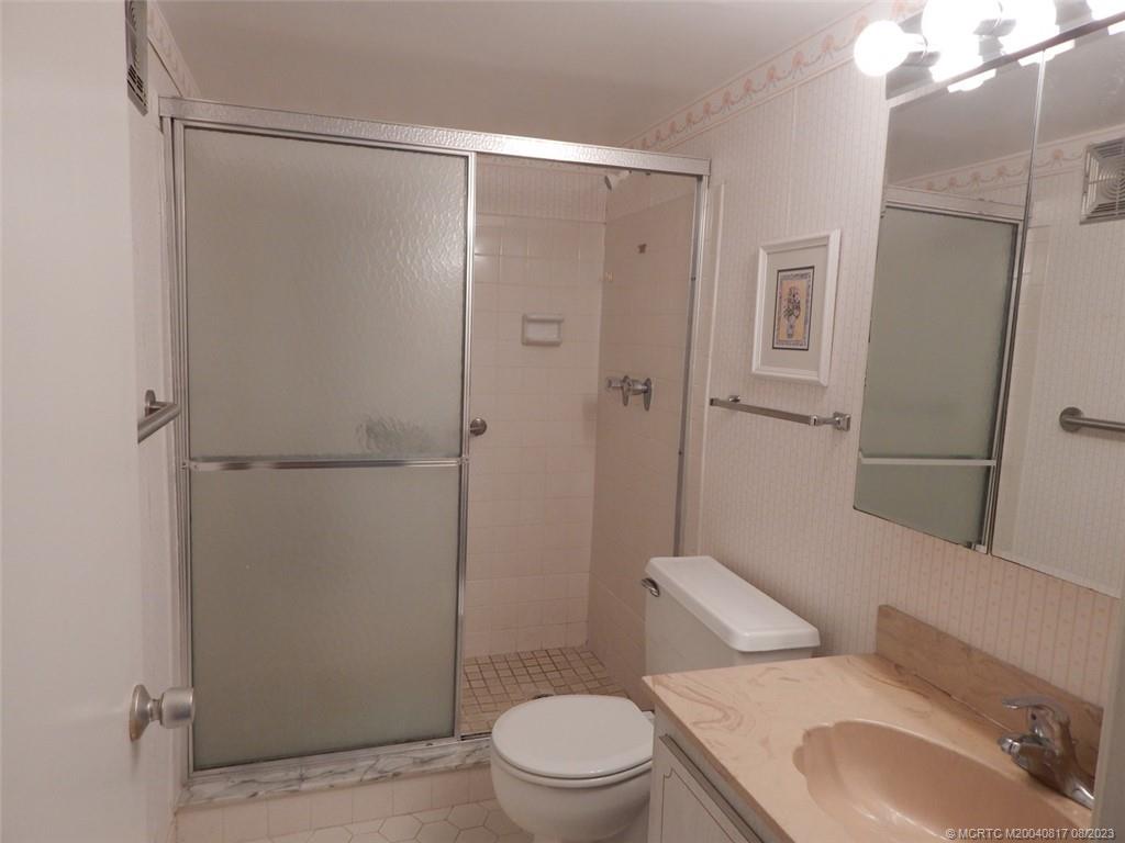 2950 Southeast Ocean Boulevard, Unit 55 Stuart, FL 34996 - Photo 17 of 24 a bathroom with a toilet sink vanity and shower