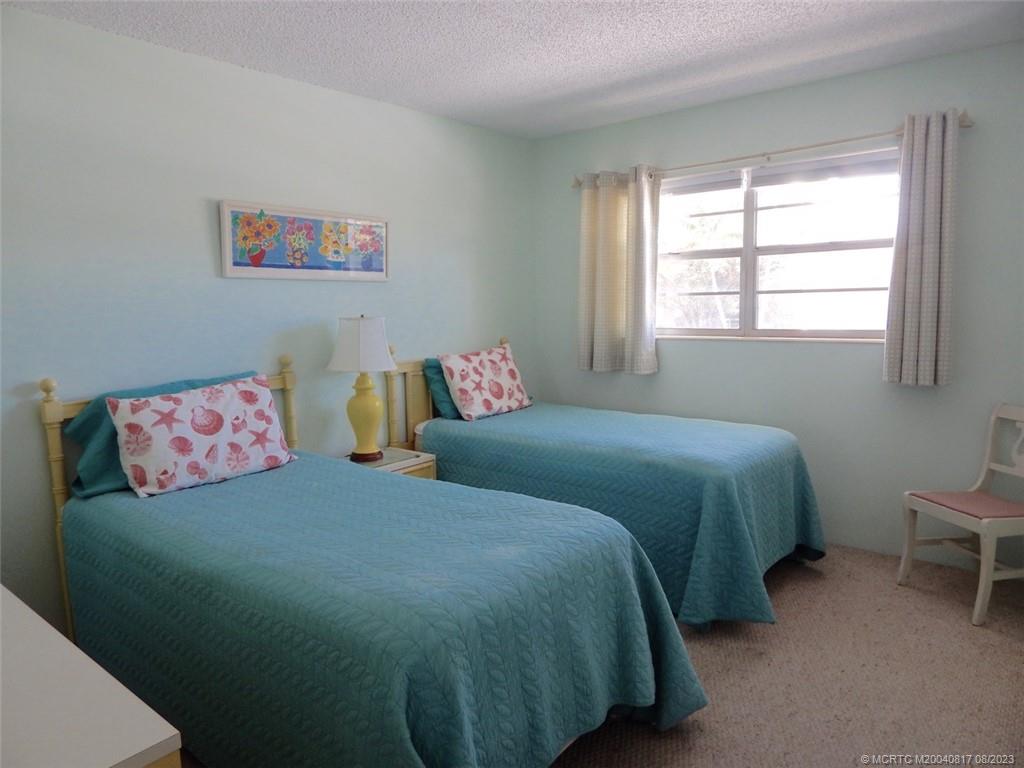 2950 Southeast Ocean Boulevard, Unit 55 Stuart, FL 34996 - Photo 19 of 24 a bedroom with a bed and a couch