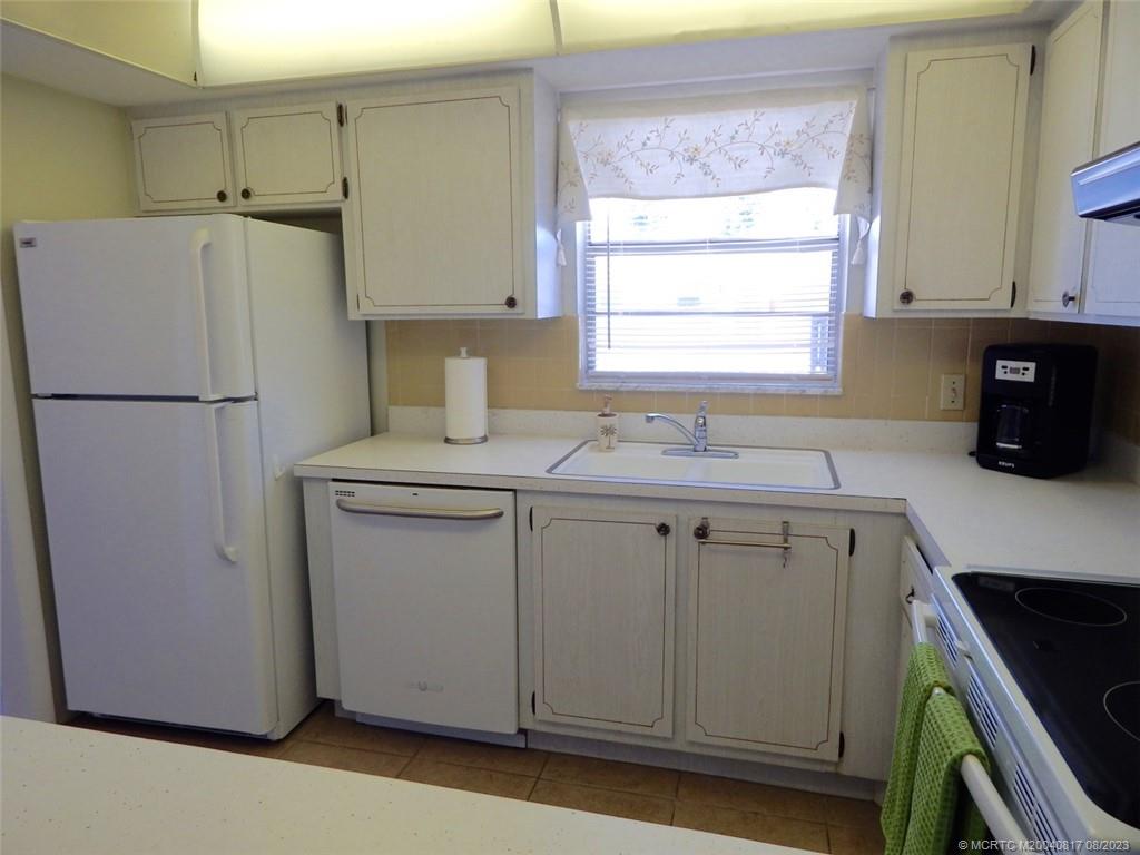 2950 Southeast Ocean Boulevard, Unit 55 Stuart, FL 34996 - Photo 4 of 24 a kitchen with a refrigerator sink and cabinets