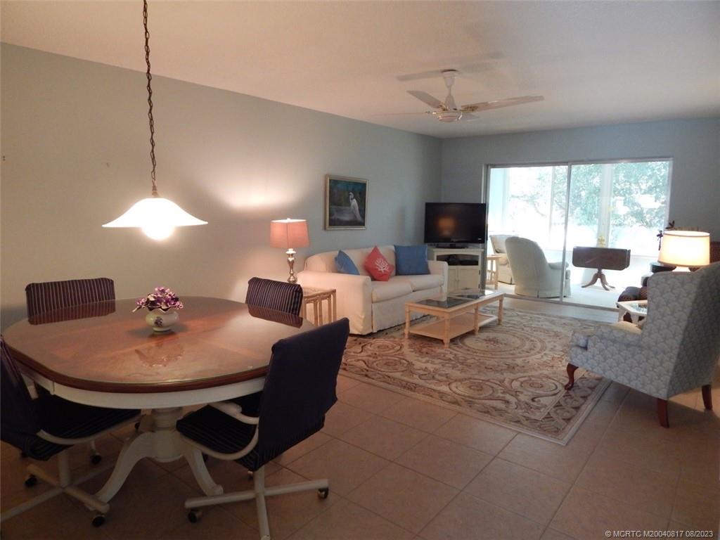 2950 Southeast Ocean Boulevard, Unit 55 Stuart, FL 34996 - Photo 5 of 24 a living room with furniture a flat screen tv and a large window