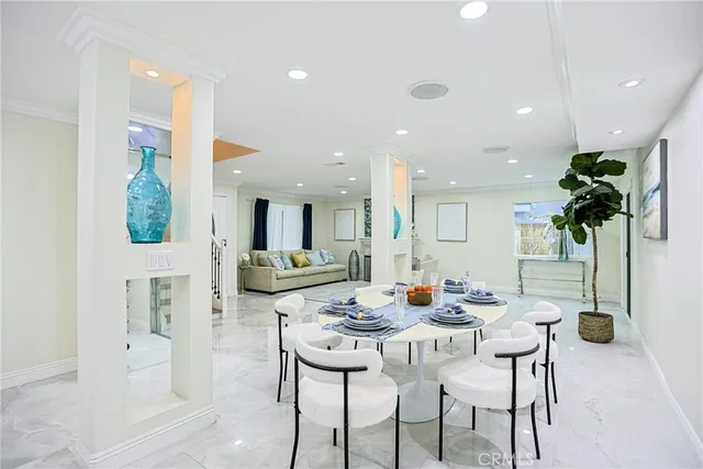 a view of a dining room with furniture and potted plants