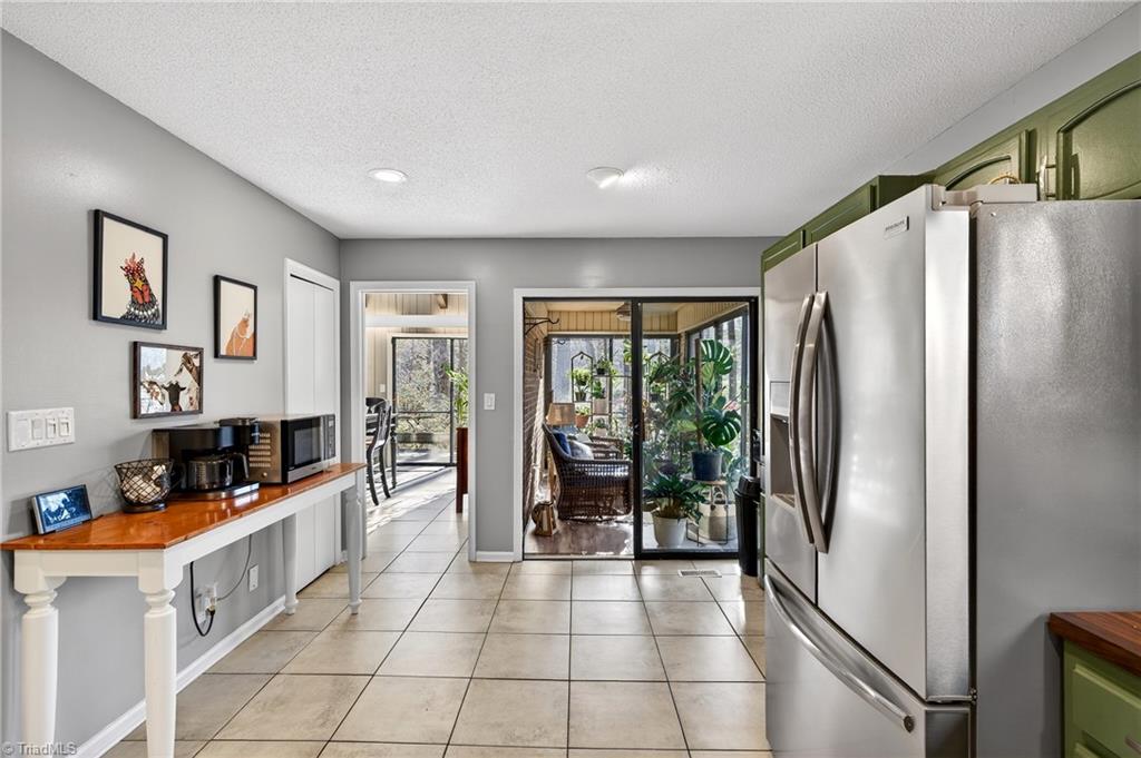 7736 Penns Grove Road Summerfield, NC 27358 - Photo 10 of 50 The kitchen leads to a 3 season sunroom!