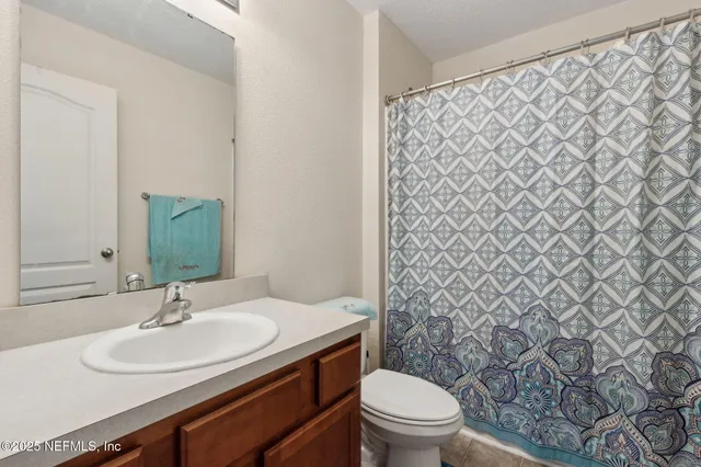 a bed room with a bed tv and a window