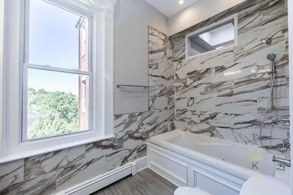 85 Regent Street, Unit 7 Boston, MA 02119 - Photo 15 of 22 a bathroom with bathtub and window