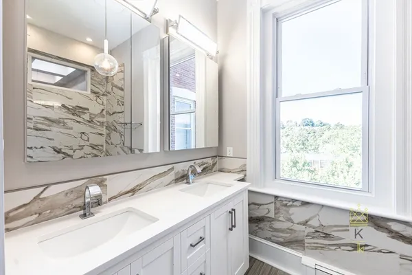 a bathroom with a granite countertop sink mirror and a window