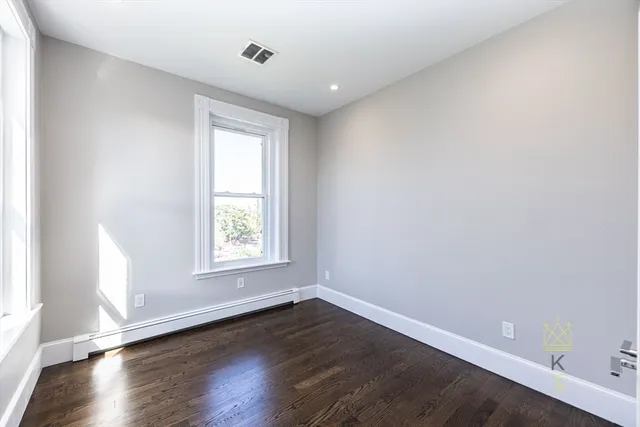 an empty room with wooden floor and window