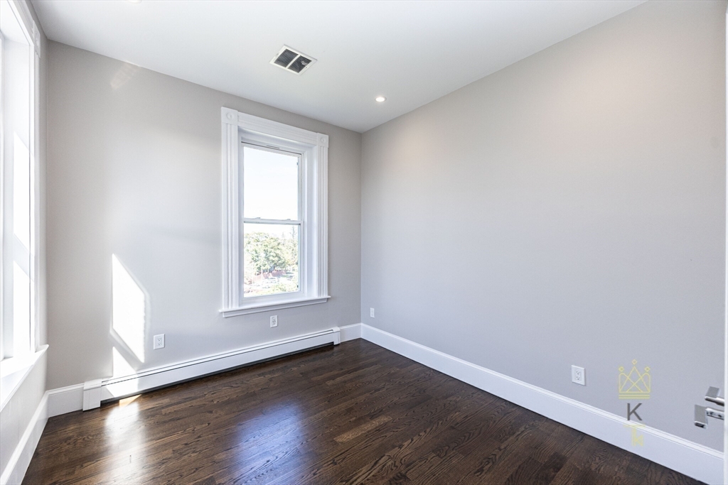 85 Regent Street, Unit 7 Boston, MA 02119 - Photo 19 of 22 an empty room with wooden floor and window