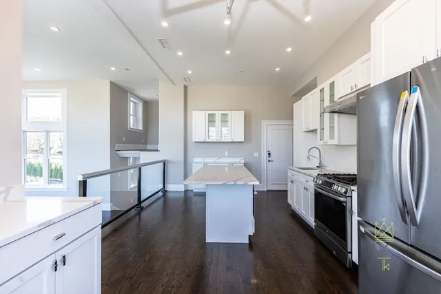 a kitchen with stainless steel appliances a refrigerator and a stove top oven
