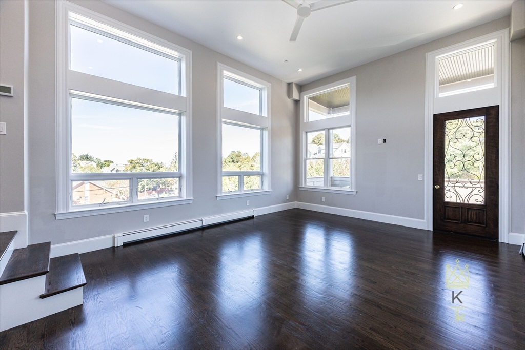 85 Regent Street, Unit 7 Boston, MA 02119 - Photo 8 of 22 a view of an empty room with wooden floor and a window
