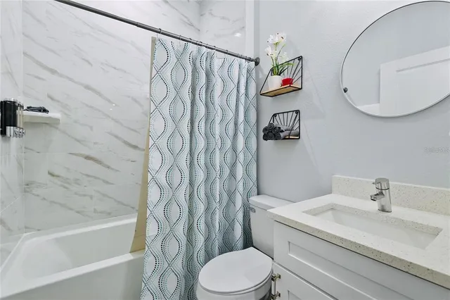 a bedroom with a bed and a flat tv screen on a dresser