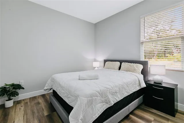 a bedroom with bed and wooden floor
