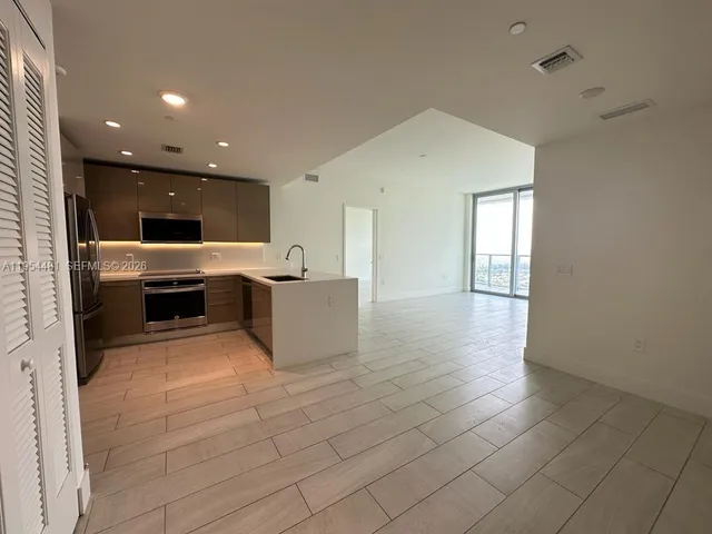 a view of kitchen with stainless steel appliances a refrigerator and a stove top oven