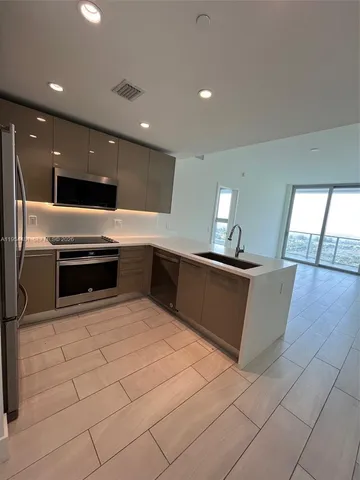 a kitchen with stainless steel appliances granite countertop a sink and a microwave