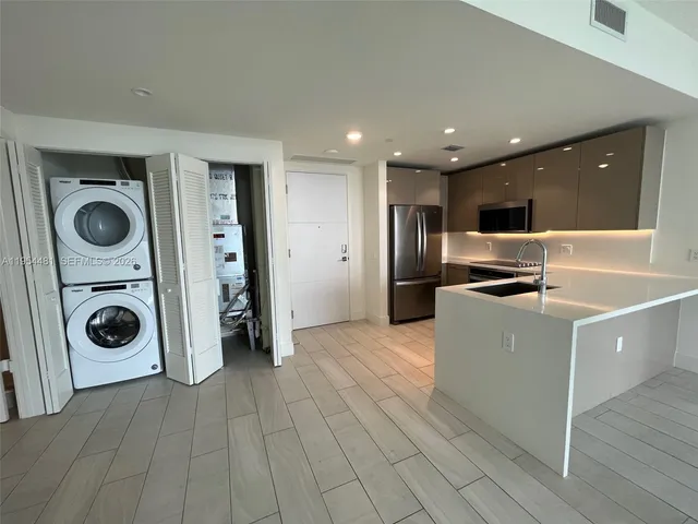 a view of a kitchen with a sink and a refrigerator