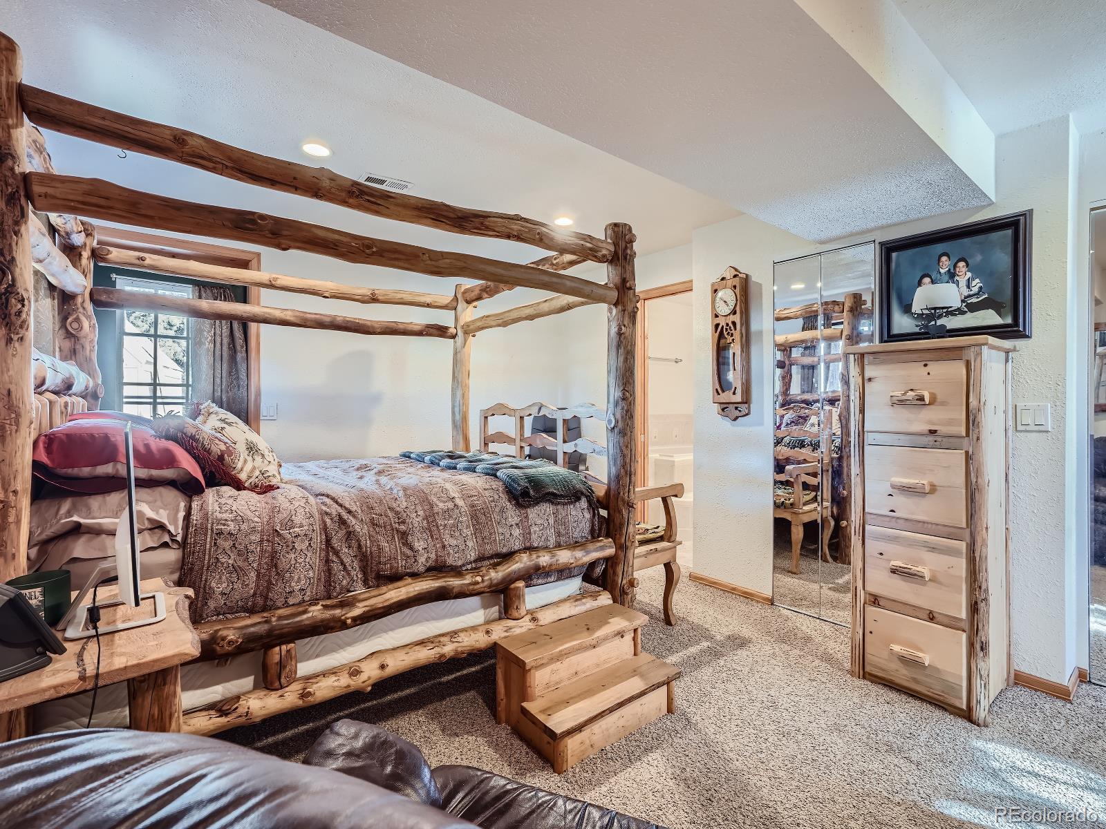 139 Hayes Street Bailey, CO 80421 - Photo 18 of 28 a bedroom with furniture and a walk in closet