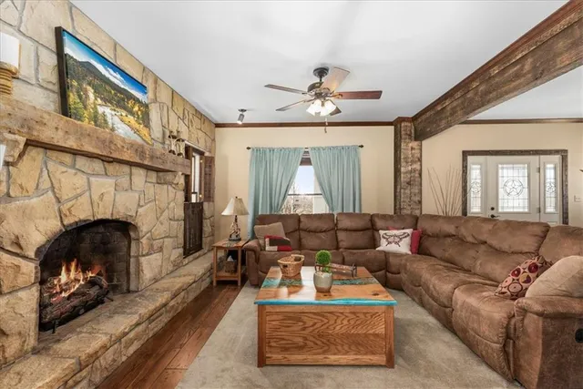 a living room with furniture a fireplace and a large window