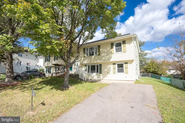 a front view of a house with a yard covered with trees