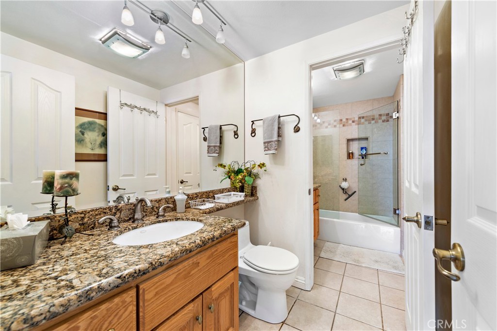 1205 Via Catalina San Clemente, CA 92672 - Photo 24 of 42 a bathroom with a granite countertop sink a toilet a mirror and shower
