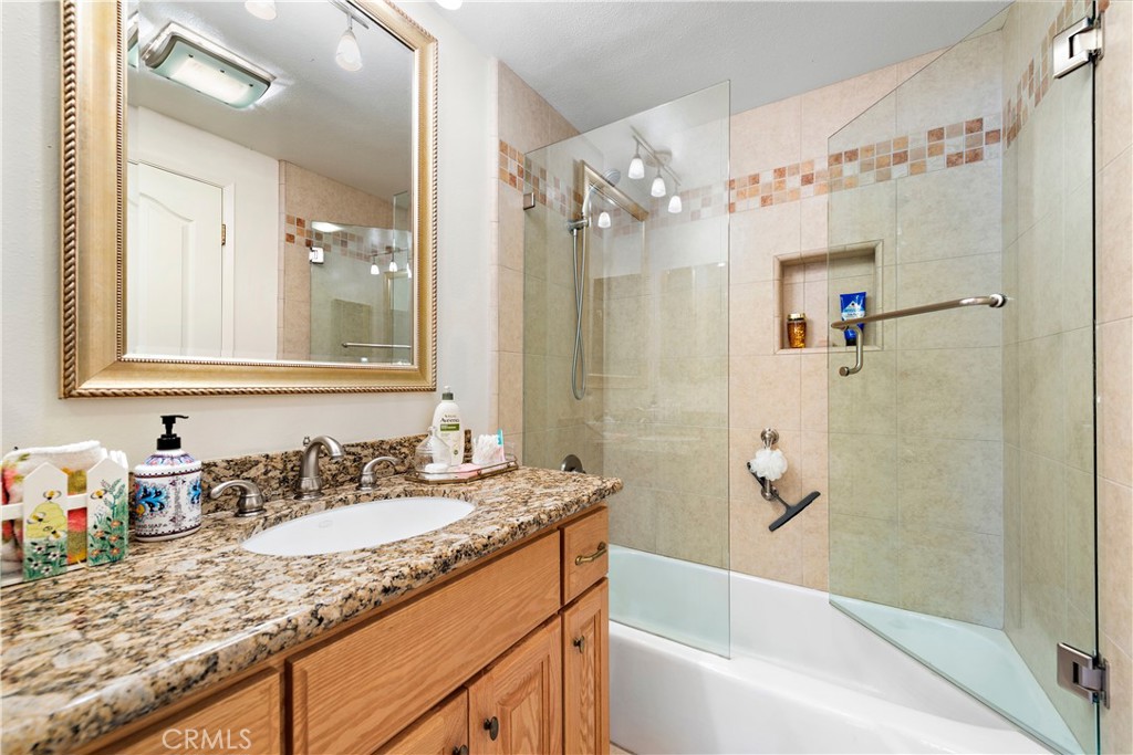 1205 Via Catalina San Clemente, CA 92672 - Photo 25 of 42 a bathroom with a granite countertop sink a mirror a shower and a bathtub
