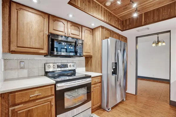 a kitchen with stainless steel appliances a stove a sink dishwasher a refrigerator and a microwave