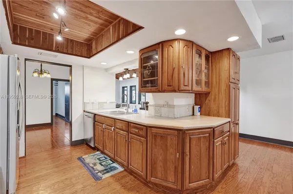 a view of a living room and kitchen with furniture wooden floor and window