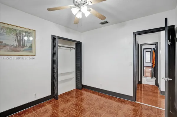 a view of a kitchen with wooden floor and a refrigerator